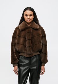 Brązowa kurtka z faux futra, krótka, z szerokim kołnierzem i prążkowanym pasem, z warstwowymi poziomymi panelami i miękką teksturą.