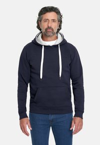 Sudadera azul marino con capucha forrada en gris, cordones blancos y un bolsillo frontal. Material de algodón con puños y dobladillo acanalados.