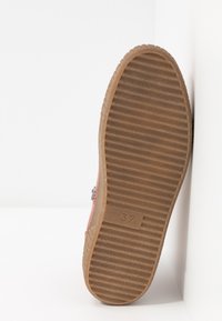 Suela de zapato con banda de rodadura de goma marrón acanalada, número de talla 37 embutido cerca del centro.