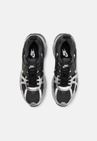 Sneaker Nike nere e argento con tomaia in rete e sintetico, dettagli testurizzati, lingua imbottita e lacci neri. Suola in gomma per trazione.