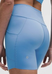 Helle blaue Sportshorts mit hohem Bund, featuring strukturierten Akzenten, Flachnähte und ein kleines Logo an der unteren linken Seite.