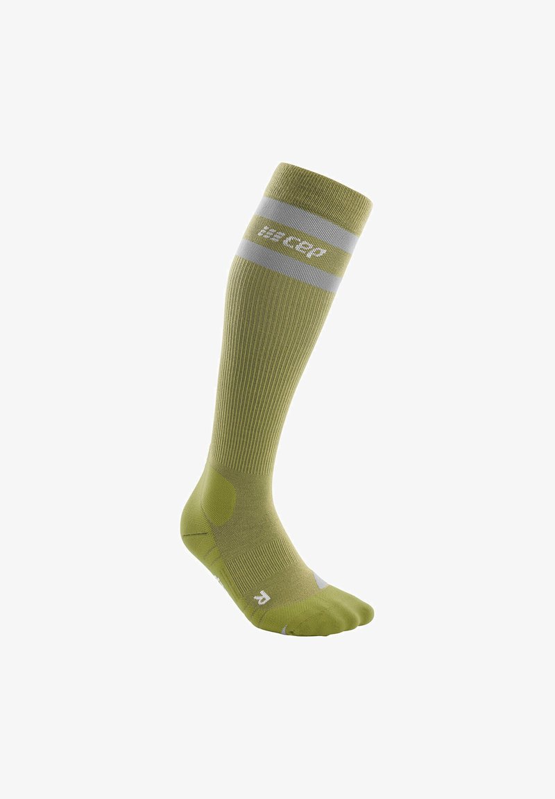 Calza compressiva al ginocchio di colore verde oliva con texture a coste, strisce riflettenti grigie, tallone e punta rinforzati, con dettaglio del logo.