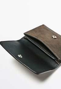 Portafoglio in pelle marrone con esterno lavorato, interno in pelle nera e chiusura a scatto argento. Contiene più scomparti per carte.