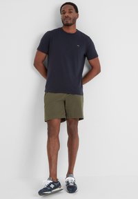 Navy blue short-sleeve t-shirt, olive green shorts, and navy sneakers with white accents. Simple design, relaxed fit, and soft texture.