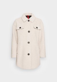 Fleece coat in off-white, featuring a pointed collar, six black buttons, and two chest pockets with flaps. Soft, textured fabric.
