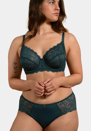 Soutien-gorge en dentelle teal avec armatures et bords festonnés, associé à un brief assorti en dentelle teal. Matériau lisse et détails en motif de feuilles.