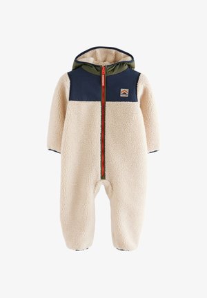 Enfant portant une veste sherpa polaire crème avec des panneaux d’épaule bleu marine et verts et une fermeture éclair rouge avec le logo Superdry.