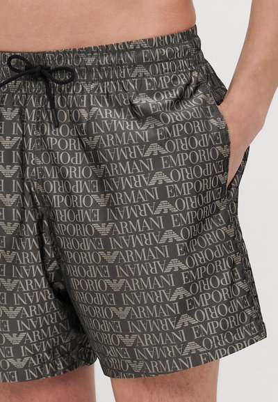 Črne kopalne hlače z ponavljajočim se potiskom besed "Armani" in "Emporio", opremljene z elastičnim pasom in stranskimi žepi.