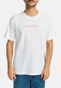 White cotton t-shirt featuring the text "FUTURE MYTHOLOGY" in pink and "RVCA" in yellow, with a relaxed fit and short sleeves.