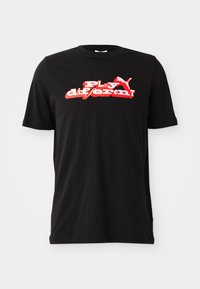 Sort bomulds T-shirt med et kraftigt rødt og hvidt grafisk design med teksten "Play different!" og et logoelement. Korte ærmer og rund hals.