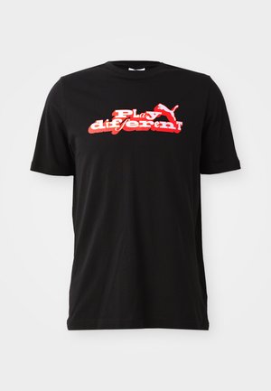 Tricou din bumbac negru, cu un design grafic îndrăzneț în roșu și alb, având textul "Joacă diferit!" și un element de logo. Mâneci scurte și gât rotund.