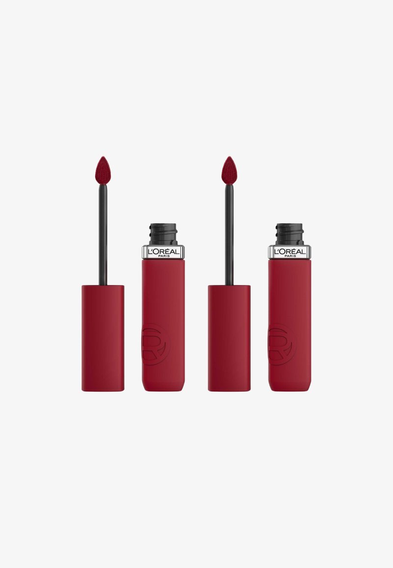 Produit à lèvres rouge avec une finition mate. Dispose d'un applicateur conique et d'un tube cylindrique à toucher doux, avec un logo en relief visible.