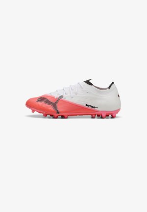 Biało-czerwony but piłkarski Puma Nitro Elite z czarnym logo Puma i korkami na białym tle, widok z boku.