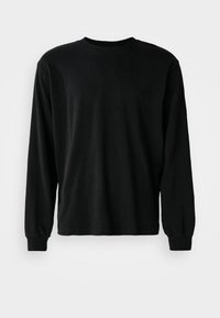 Camisa negra de manga larga hecha de algodón, con cuello redondo, corte relajado y puños ajustados, con una textura suave y sin patrones visibles.