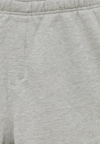 Grijze katoenen sweatpants met een zachte textuur, een elastische tailleband en minimale stikdetails. Geen zichtbare zakken of patronen.