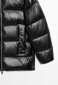 Black puffer jacket with quilted design, shiny nylon exterior, full zipper, and side pocket. Features a relaxed fit and soft texture.