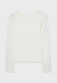 Biely dlhý crop top s okrúhlym výstrihom a detailom prekrytia v štýle tielka na chrbte, zobrazený plocho na svetlosivom pozadí.