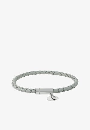 Hellgraues geflochtenes Lederarmband mit einem zylindrischen silbernen Verschluss und zwei kleinen runden silbernen Anhängern, die daran hängen.