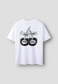 Vit bomulls t-shirt med en svart grafik av två körsbär och texten "MINDRE SKIT MER KOMPETENS" på baksidan. Kort ärm, avslappnad passform.