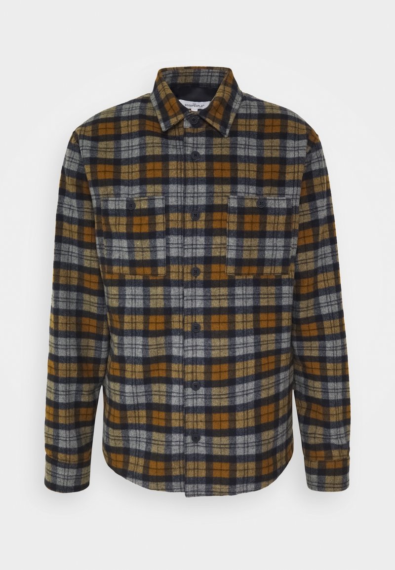 Flannel shirt featuring a plaid pattern in dark blue, mustard yellow, and gray tones. It has a button-up front and two chest pockets.