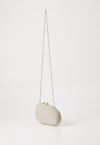 Beige oval clutch taske med en glat tekstur, guld kæde rem og rund lås. Simpelt design, kompakt form.