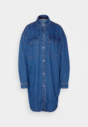 Denim srajca v modri barvi, z zapenjanjem spredaj, dvema žepoma na prsih, dolgimi rokavi in klasičnim ovratnikom. Teksturirana tkanina s kontrastnim šivanjem.