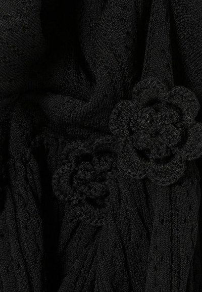 Tessuto di maglia nero con dettagliati motivi floreali all'uncinetto e punti texturizzati che formano forme di fiori in rilievo.