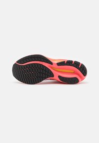 Sole di scarpe da corsa con motivo di battistrada in gomma nera, intersuola rosa e accenti gialli. Texturizzata per grip e ammortizzazione.