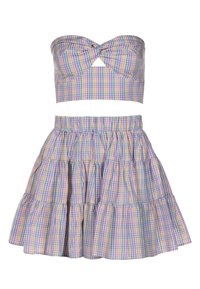 Completo a due pezzi con un crop top senza spalline annodato e una gonna a campana a strati. Presenta un motivo a scacchi pastello in diversi colori.