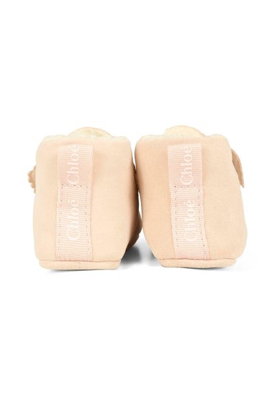 Jasnoróżowe zamszowe kapcie z miękkim wnętrzem, zaokrąglonym tyłem, z teksturowanym paskiem z logo "Chloé" na każdym pięcie.