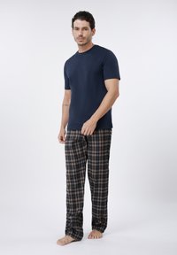 Tamsiai mėlyni trumpomis rankovėmis marškinėliai derinami su rudais ir mėlynais languotais pižamos kelnėmis, pagamintos iš lengvos medžiagos, laisvo silueto ir tiesaus kirpimo.