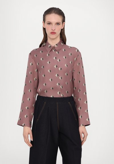 Vaaleanpunainen pitkähihaisuus paita, jossa on mustista ja kermaista muodostuva geometrista timanttikuvioita. Kauluksellinen muotoilu, kevyt kangas.