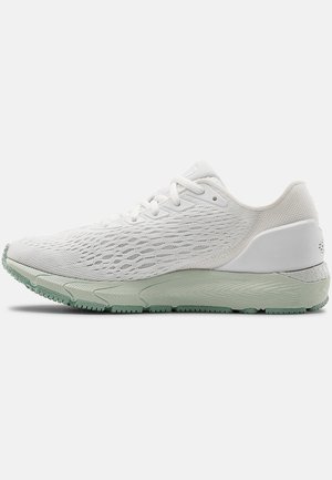 Zapatilla deportiva blanca con parte superior de punto texturizado, que cuenta con un collar acolchado, suela verde y un diseño aerodinámico para un soporte transpirable.