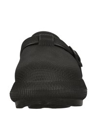 Svart slip-on sko med texturerad gummiyta, ett band över mittfoten och en vadderad sula, utformad för komfort och enkel användning.