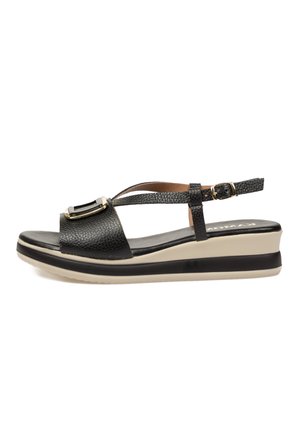 Sandalia negra de cuero con empeine abierto y tira trasera, detalle de hebilla dorada y suela plataforma gruesa en beige y negro.