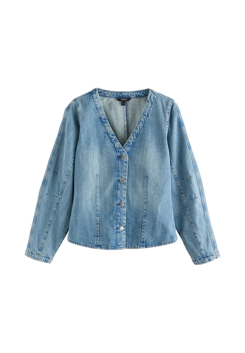 Világoskék farmerdzseki V-nyakkivágással, hosszú ujjakkal és gombos rögzítéssel. Kivarrt részletekkel és laza szabással rendelkezik.