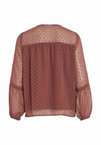 Transparent, rostfärgad blus med ett prickigt mönster, långa ballongärmar och rynkad detalj på baksidan. Mjuk, lättviktsmaterial.