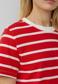 Rotes kurzärmliges T-Shirt mit horizontalen weißen Streifen, Rundhalsausschnitt und weichem Baumwollstoff mit sichtbaren Nahtdetails.
