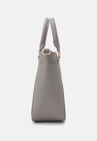 Sac à main synthétique gris avec un design structuré, des poignées courtes, du matériel en tonalité dorée et une surface texturée. Vue de côté en biais mettant en avant sa forme.