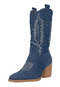 Bota de vaquero de denim con intrincadas costuras blancas, puntera afilada y tacón grueso. Cuenta con tiradores para facilitar el uso.