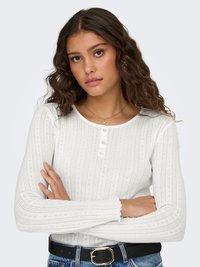 Biely dlhý rukáv s textúrovanými pruhmi, s okrúhlym výstrihom a zapínaním na tri gombíky. Ukončený volánikovými manžetami.
