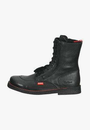 Bottes noires en cuir à la cheville avec un bout rond, un laçage à l'avant et une fermeture éclair sur le côté. Présente des coutures rouges et un logo Kickers sur le côté.