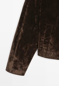 Brun fløjlsjakke med en blød tekstur, en enkelt påsyet lomme og en skræddersyet pasform med en struktureret krave.