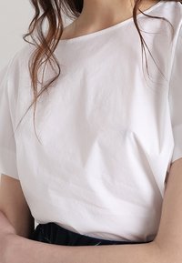 Vit, kortärmad topp i lätt tyg, med en avslappnad passform och båthals, med jämn textur och minimal design.