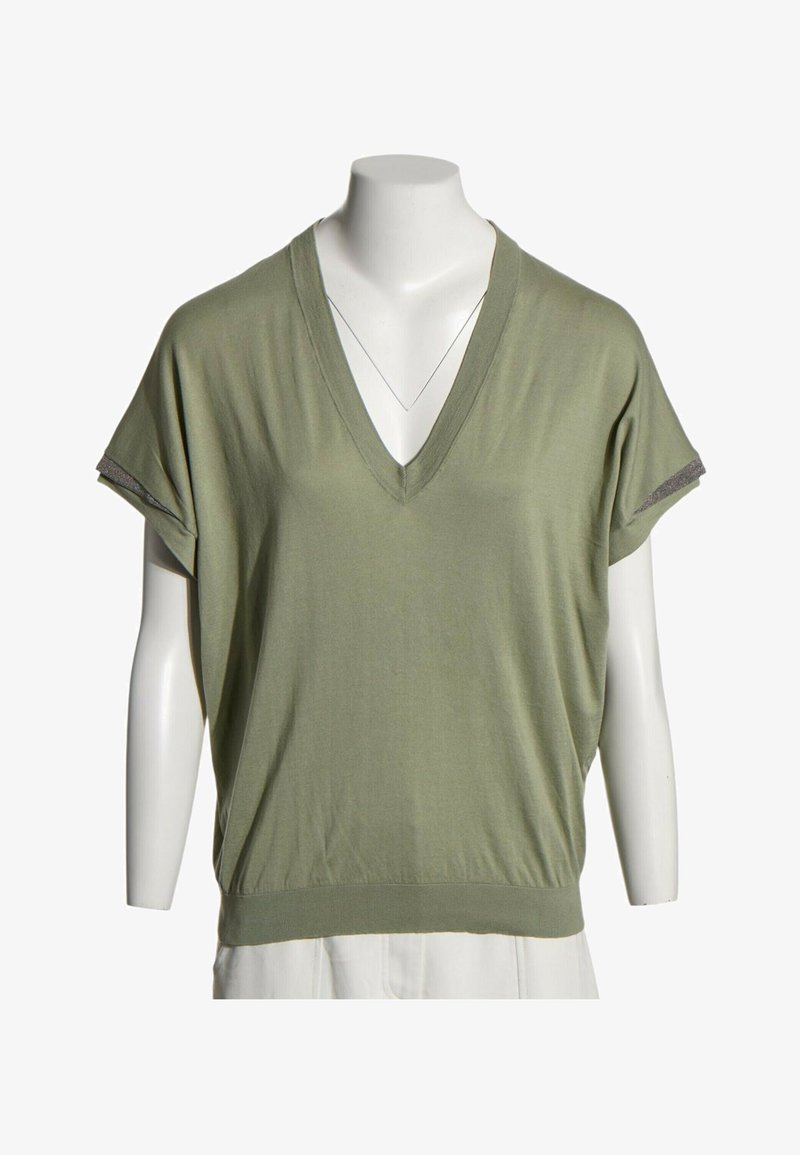 Top vert clair à manches courtes avec col en V et détails de poignets sur les manches, présenté sur un buste de mannequin blanc.