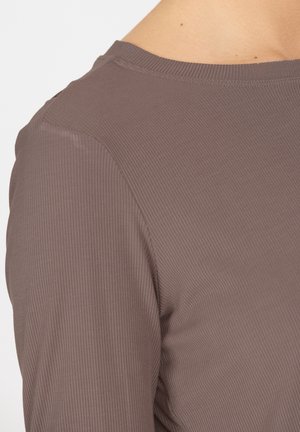 Maglietta a maniche lunghe in mauve polveroso, texture a coste, collo rotondo, design aderente, con dettagli di cucitura minima lungo il colletto.