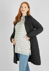 Abrigo largo negro acolchado con capucha, que presenta una cremallera frontal y un suéter de rayas gris texturizado tejido debajo. Botones en el costado del suéter.