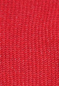 Tissu tricoté en rouge vif, présentant un motif texturé avec des lignes verticales alternées et un léger brillant grâce à des fibres mélangées.