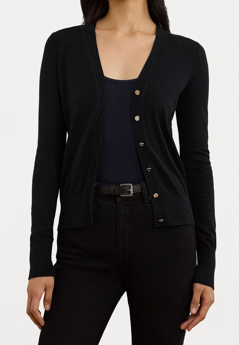 Svart cardigan i mjukt stickat tyg, med V-ringning, långa ärmar och knappar i guldton framtill för stängning.