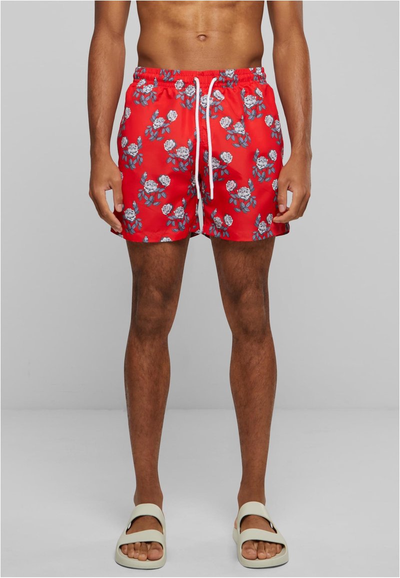 Costume de baie roșii cu un model floral care prezintă trandafiri albi și frunze albastre; talie elastică cu închidere cu șnur; material ușor.